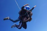 male tandem skydiving student screams with excitement in skydiving freefall