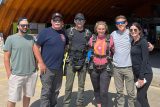 group poses in front of the hangar for a pre-jump photo