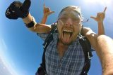male tandem student rocks his skydive with tongue out