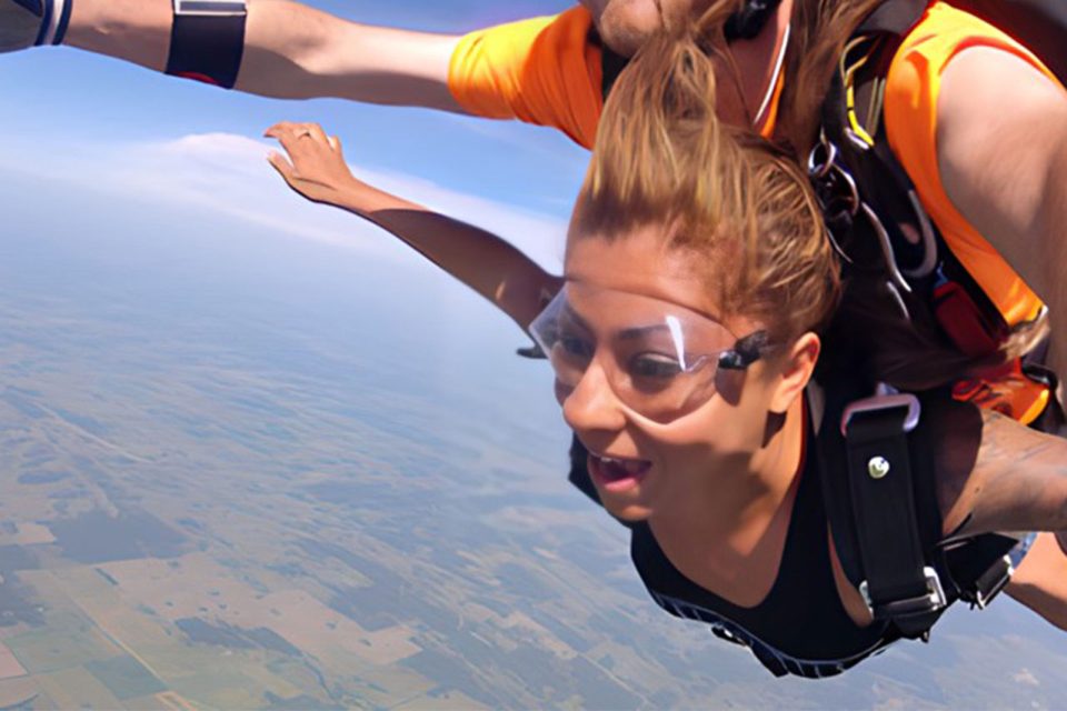 young female stares at the ground with mouth open in skydiving freefall