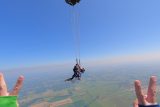 tandem skydiving student with instructor moments after parachute deployed