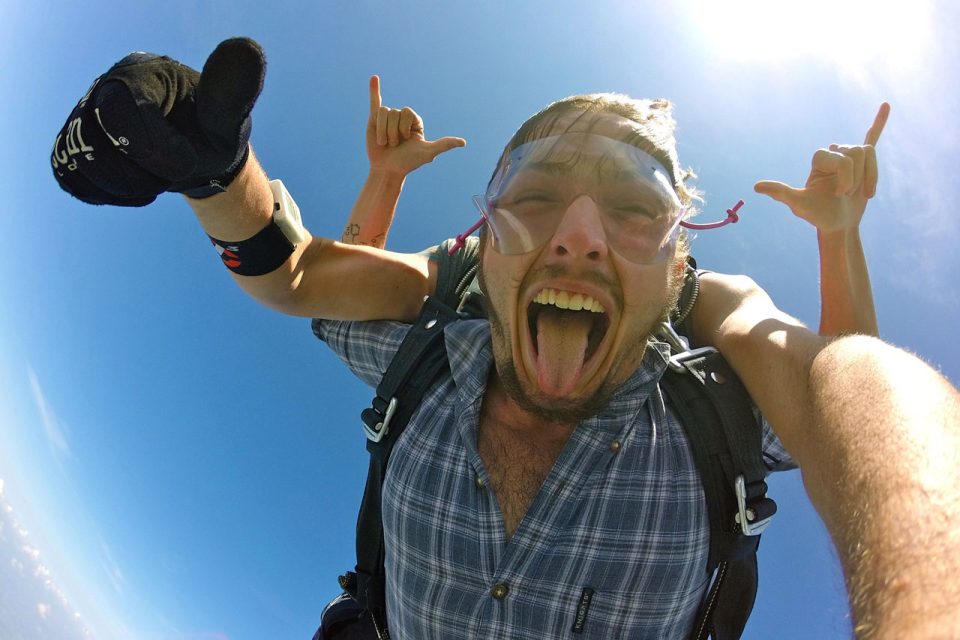 male tandem student rocks his skydive with tongue out