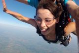 female skydiver smiles with tongue out in skydiving freefall