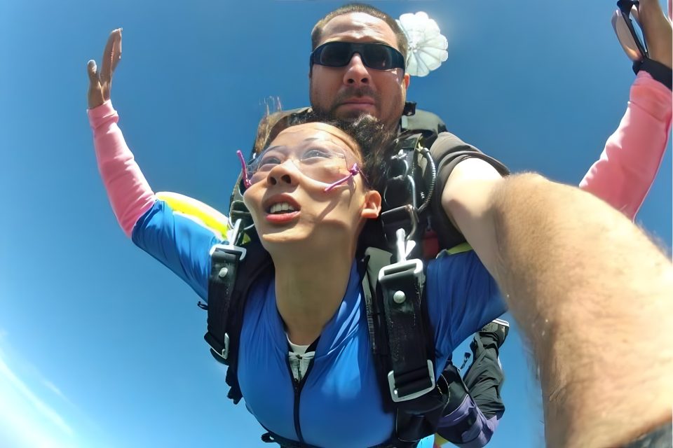woman puts hands up in skydiving freefall