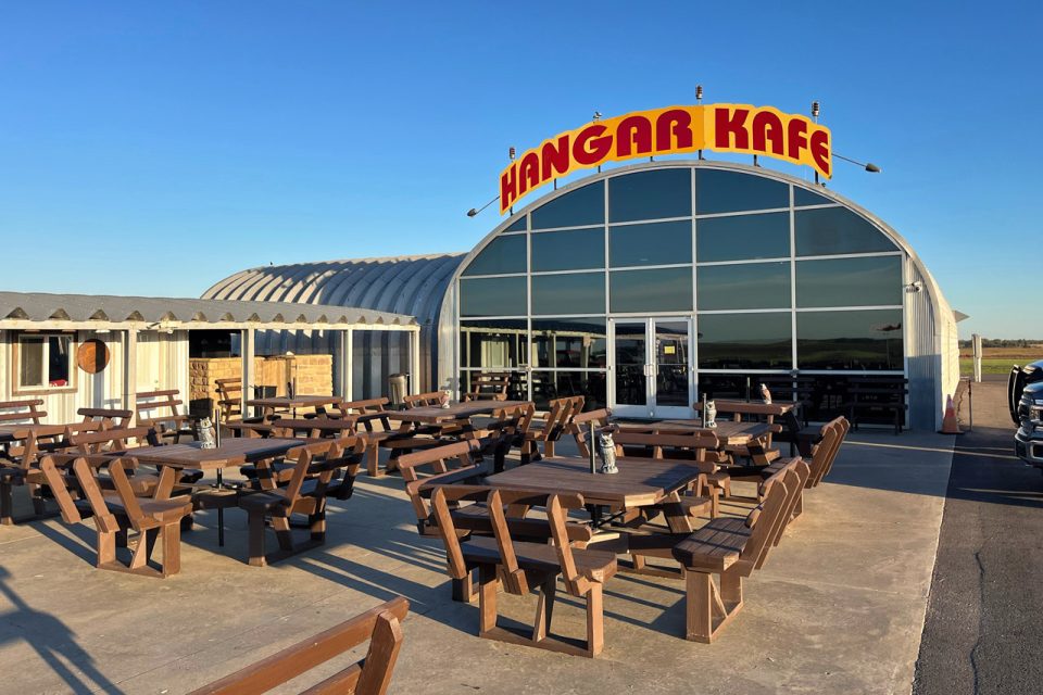 exterior photo of the hangar kafe with picnic style tables