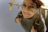 woman looks down to earth in skydiving freefall