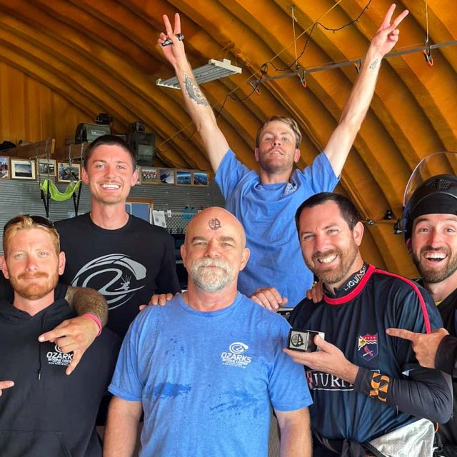 OZARKS Skydive Center staff celebrates learn to skydive student who has A stamp on his forehead after completing his learn to skydive program