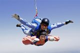 tandem skydiver looks pensive while in freefall