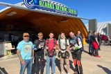 five guys of various ages pose for photo in front of Ozarks Skydive Center sign on hangar