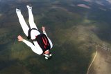 man in white jumpsuit looks like he's flying through the sky in freefall