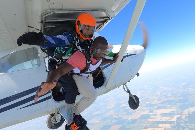 young male about to exit plane for his first tandem skydive