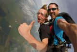 tandem student gives a thumbs up in skydiving freefall